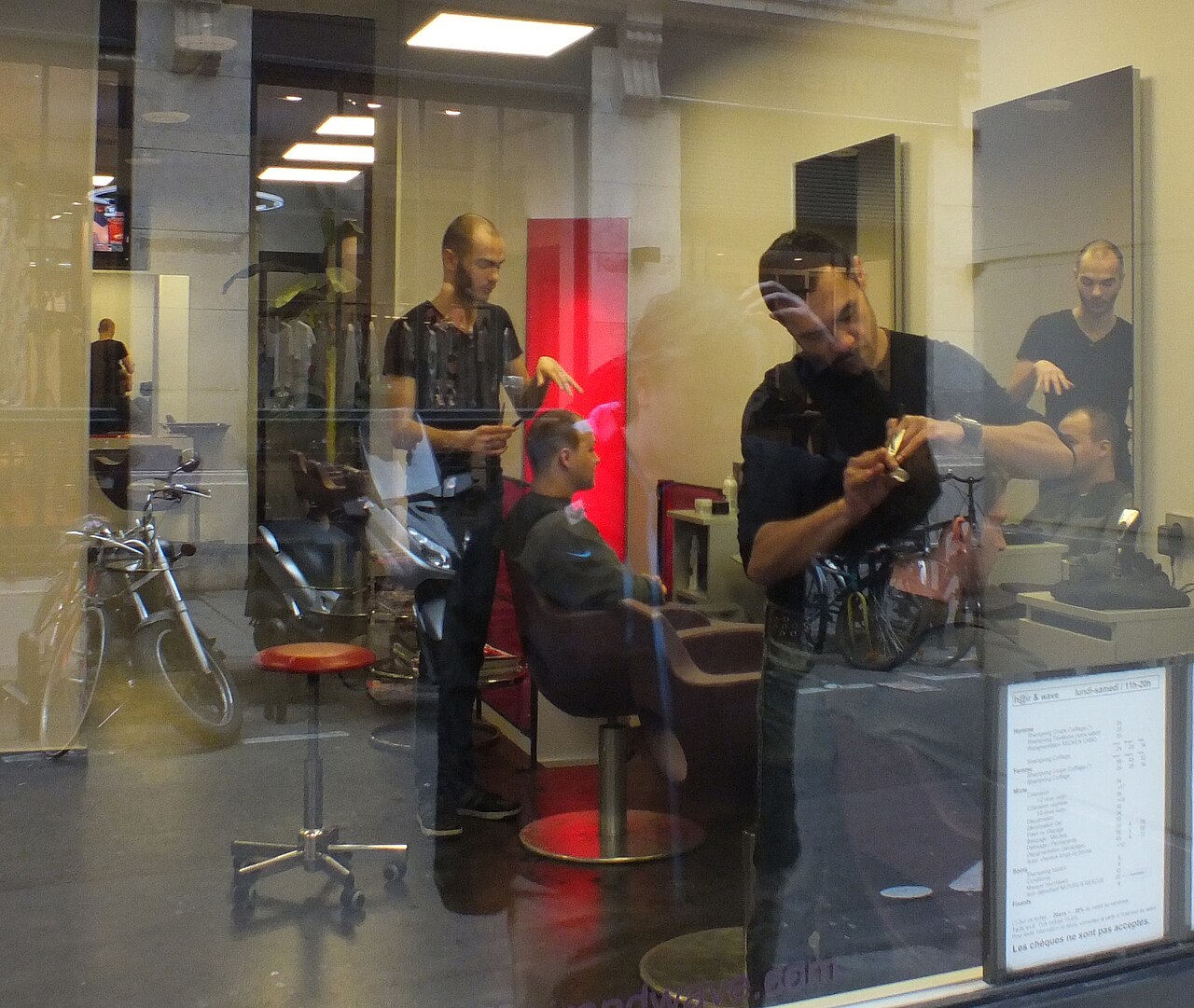 Barbers working with clients inside a salon.